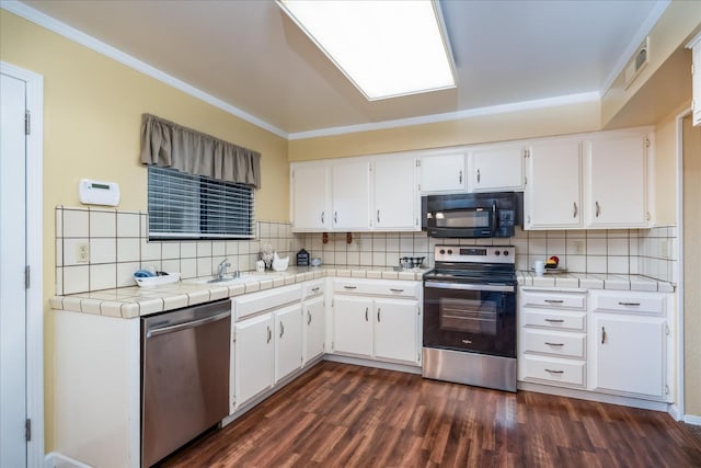 kitchen with tile counters, white cabinets, dark wood-style floors, stainless steel appliances, and backsplash