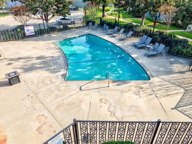 community pool featuring a patio area and fence