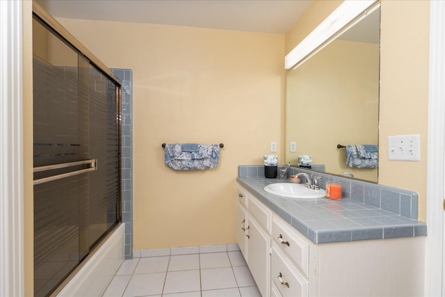 bathroom with tile patterned flooring, enclosed tub / shower combo, and vanity