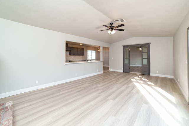 unfurnished living room featuring vaulted ceiling, sink, ceiling fan, and light hardwood / wood-style flooring