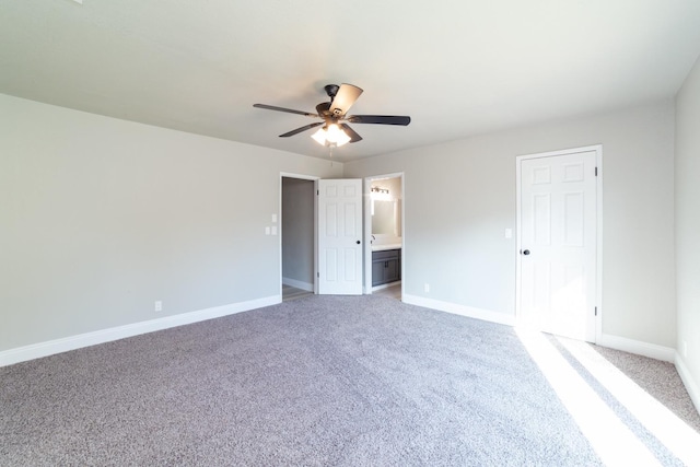 unfurnished bedroom featuring ceiling fan, ensuite bath, and carpet