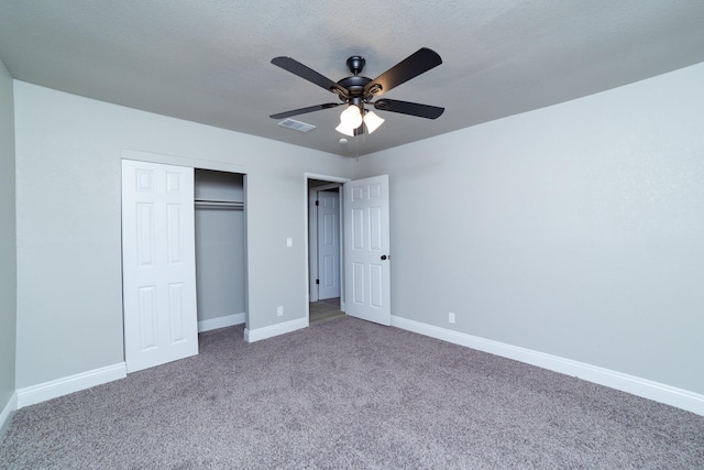 unfurnished bedroom with carpet, a closet, visible vents, ceiling fan, and baseboards