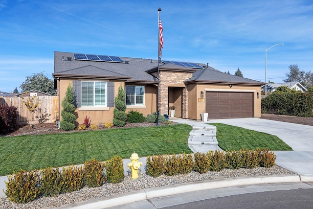 view of front facade with solar panels, a garage, and a front lawn