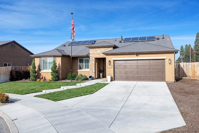 single story home with solar panels, a garage, and a front lawn