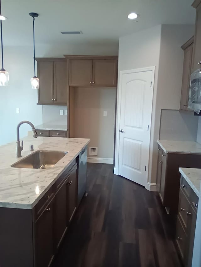 kitchen with light stone countertops, sink, dishwasher, dark hardwood / wood-style floors, and hanging light fixtures