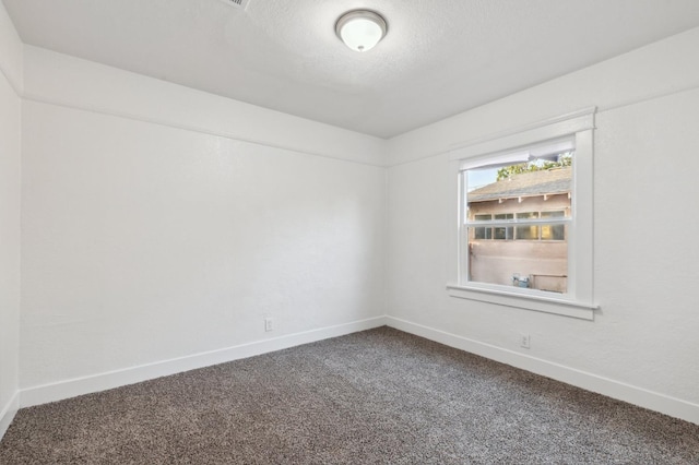 carpeted empty room with a textured ceiling