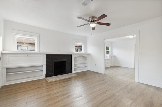 unfurnished living room with ceiling fan, light hardwood / wood-style floors, and a brick fireplace