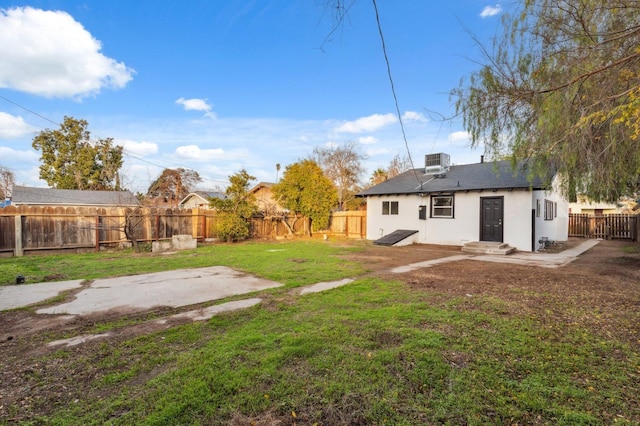 back of house featuring central AC, a yard, and a patio