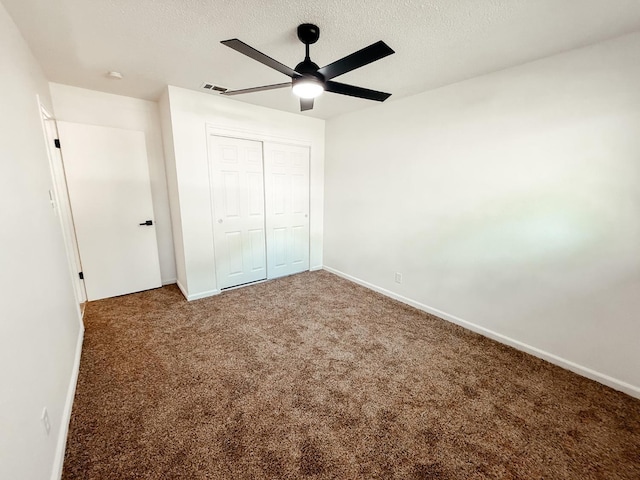 unfurnished bedroom featuring ceiling fan, a closet, carpet, and a textured ceiling