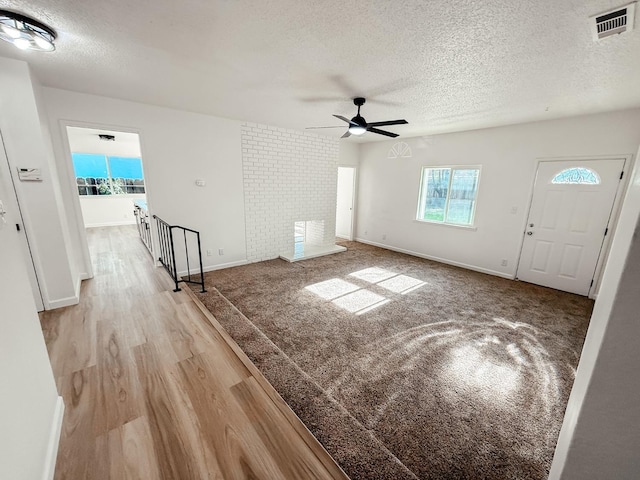 interior space featuring a textured ceiling, light hardwood / wood-style floors, ceiling fan, and a healthy amount of sunlight