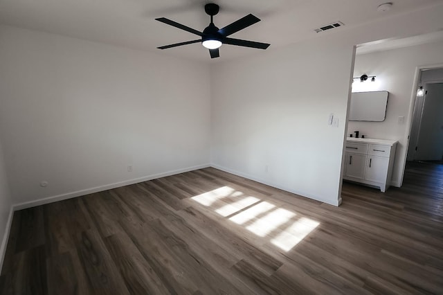 spare room with ceiling fan and dark wood-type flooring