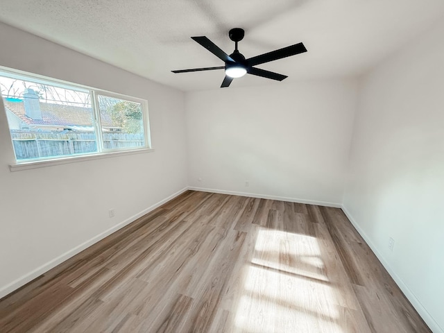 empty room with light wood-type flooring and ceiling fan