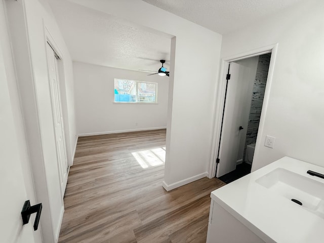 bathroom featuring ceiling fan, wood-type flooring, a textured ceiling, and vanity