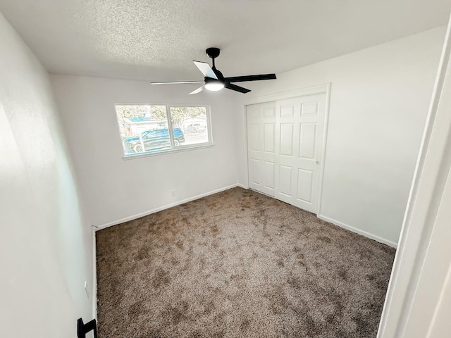 unfurnished bedroom with carpet flooring, ceiling fan, a closet, and a textured ceiling