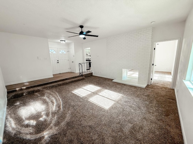 unfurnished living room featuring a fireplace, a textured ceiling, carpet floors, and ceiling fan