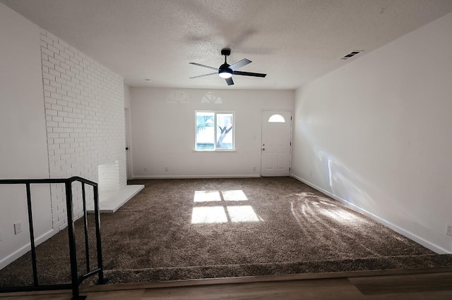 carpeted spare room with ceiling fan and a textured ceiling