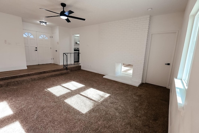 unfurnished living room with ceiling fan and dark carpet