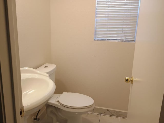 bathroom with tile patterned flooring, toilet, and sink