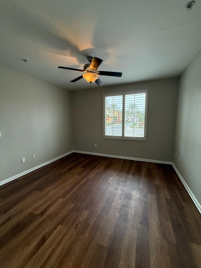 spare room with ceiling fan and dark hardwood / wood-style floors