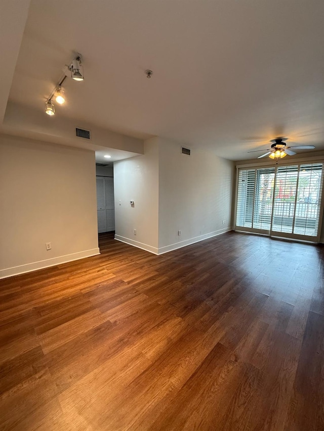 empty room with wood-type flooring, track lighting, and ceiling fan