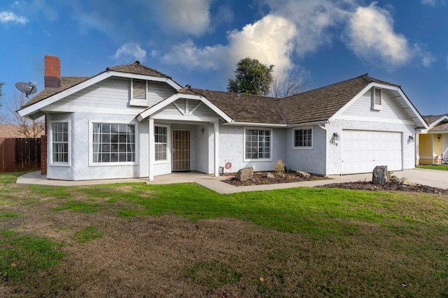 view of front of property featuring a front lawn and a garage