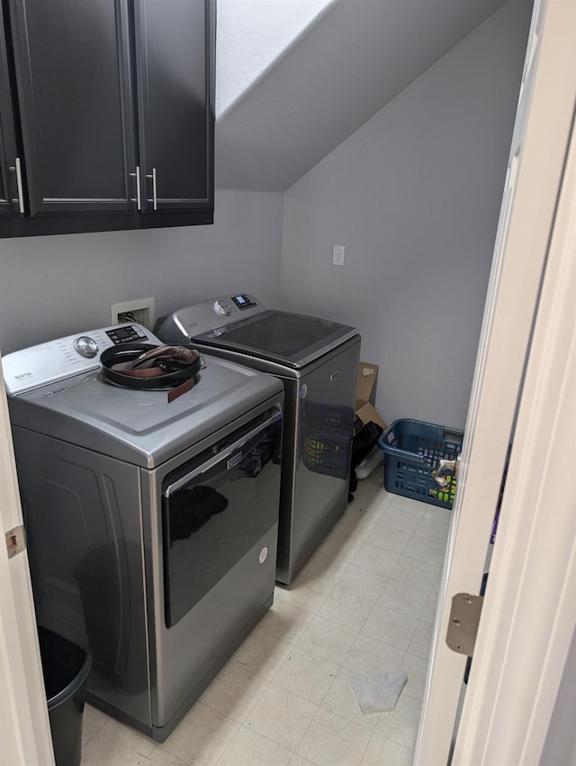 washroom with cabinet space and washer and clothes dryer