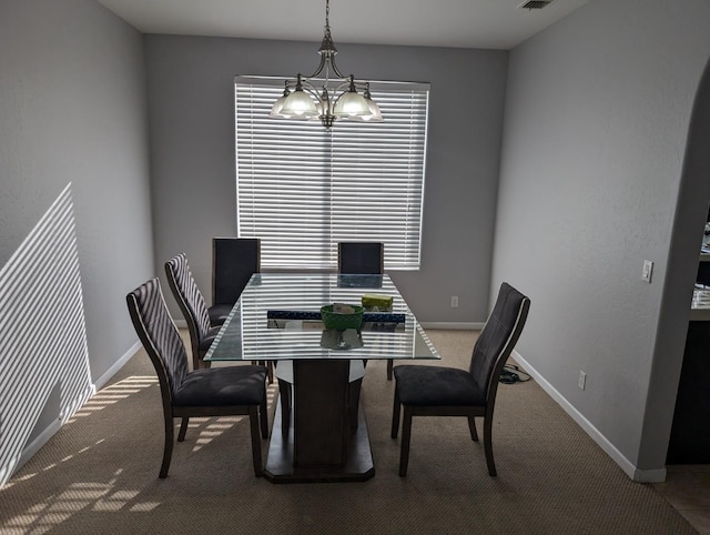 carpeted dining space featuring baseboards, visible vents, and a notable chandelier