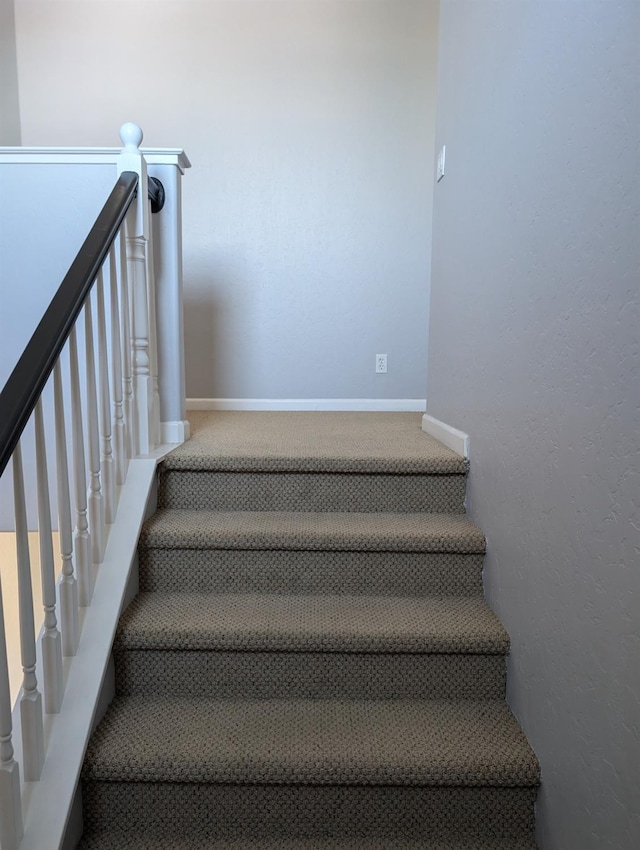 stairs with carpet floors and baseboards