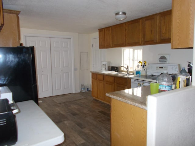 kitchen with kitchen peninsula, black fridge, sink, range, and dark hardwood / wood-style floors