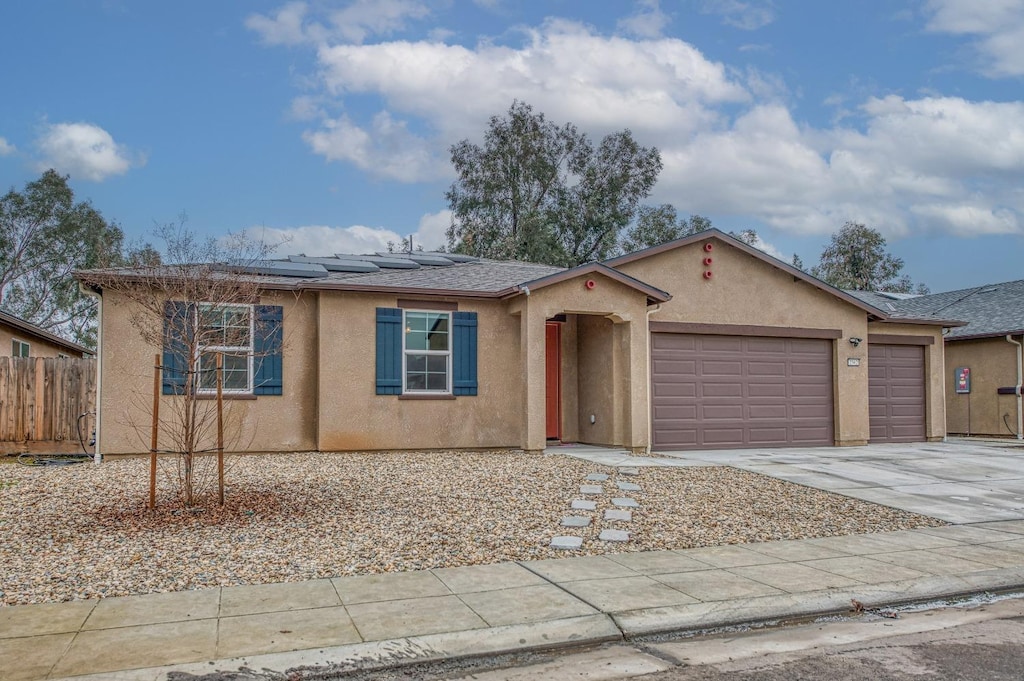 ranch-style home with solar panels and a garage