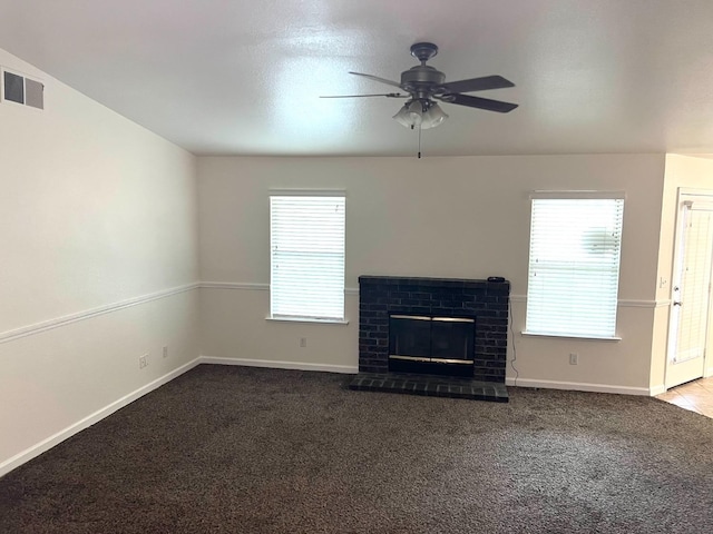 unfurnished living room featuring carpet, ceiling fan, and a brick fireplace