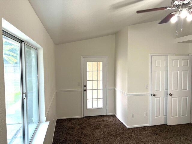 entryway with ceiling fan, lofted ceiling, and dark carpet