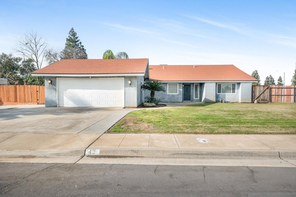 ranch-style house featuring a garage and a front lawn