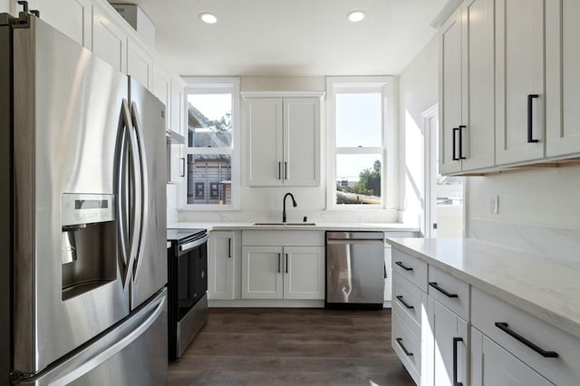 kitchen featuring white cabinets, light stone countertops, sink, and appliances with stainless steel finishes