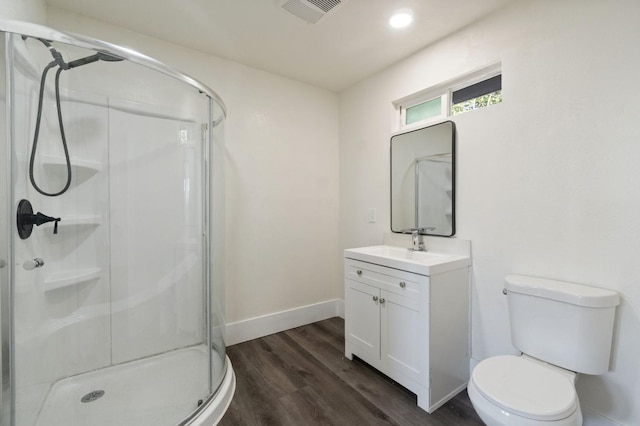 bathroom with a shower with door, vanity, wood-type flooring, and toilet