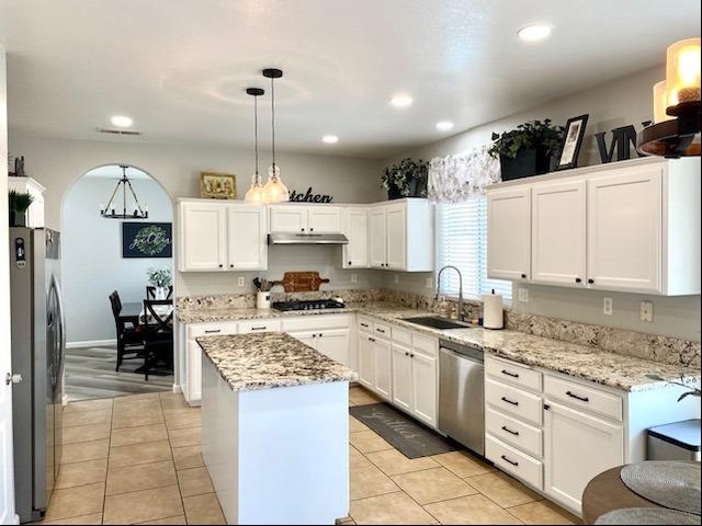 kitchen featuring pendant lighting, a center island, white cabinets, sink, and stainless steel appliances