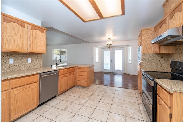 kitchen with sink, light stone counters, light tile patterned floors, appliances with stainless steel finishes, and kitchen peninsula