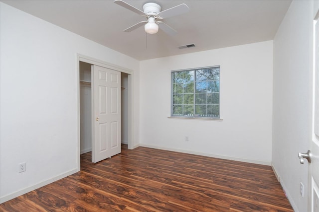 unfurnished bedroom with dark wood-type flooring, ceiling fan, and a closet