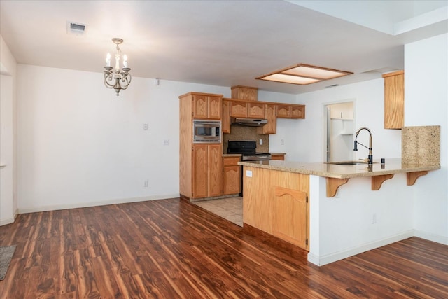 kitchen with stainless steel microwave, dark hardwood / wood-style flooring, black electric range, and kitchen peninsula