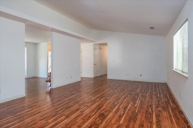 unfurnished room with lofted ceiling and dark wood-type flooring