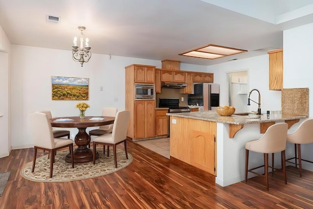 kitchen featuring sink, refrigerator, electric range, stainless steel microwave, and kitchen peninsula