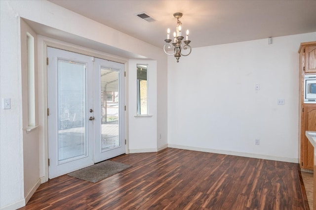 entryway featuring dark hardwood / wood-style floors, french doors, and a chandelier