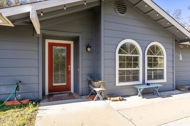 view of exterior entry with a patio