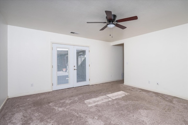 carpeted empty room featuring a textured ceiling, french doors, and ceiling fan