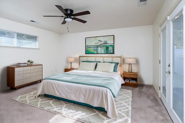 carpeted bedroom with ceiling fan and multiple windows