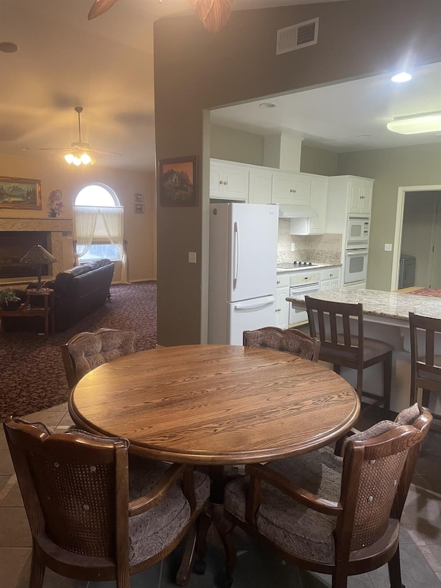 tiled dining space featuring ceiling fan