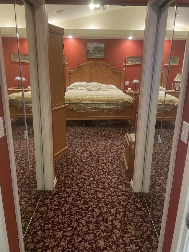 carpeted bedroom with ornamental molding and multiple closets