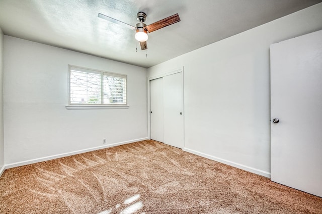 unfurnished bedroom featuring carpet flooring, a closet, and ceiling fan