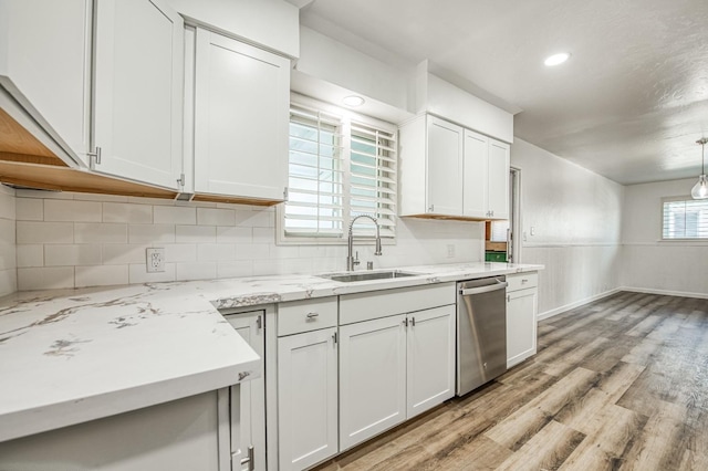 kitchen featuring pendant lighting, dishwasher, white cabinetry, and sink