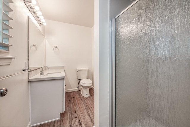 bathroom featuring hardwood / wood-style floors, vanity, toilet, and a shower with shower door